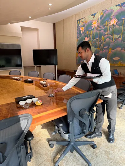 Butler preparing glasses and refreshments for a boardroom meeting